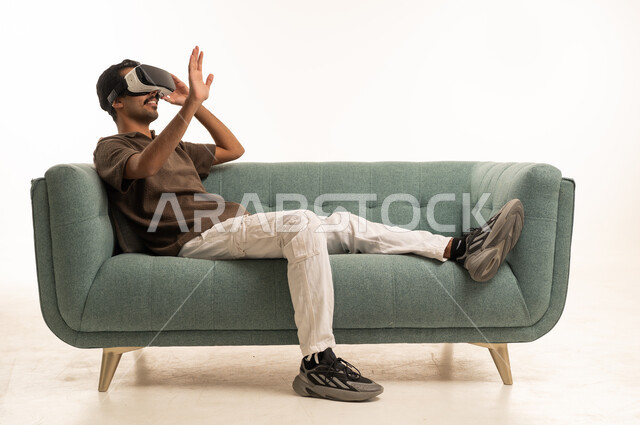 Arab Man Using VR Headset on Sofa in Studio