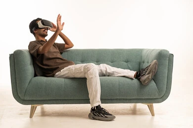 Arab Man Using VR Headset on Sofa in Studio