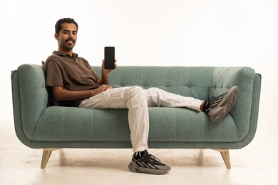 شاب عربي يحمل هاتف ذكي في استوديو