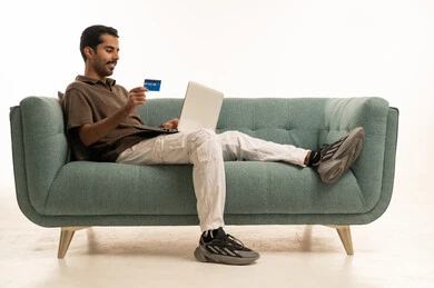 Saudi Man Shopping Online with Laptop and Credit Card