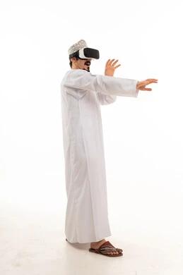 رجل عُماني يستخدم نظارة الواقع الافتراضي بخلفية بيضاء