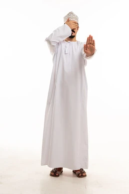 رجل عماني يشير بالتوقف ويغطي عينيه في الاستوديو