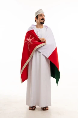 رجل عماني بالعلم الوطني والزي التقليدي
