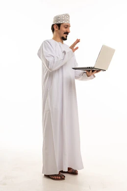 رجل عُماني يستخدم كمبيوتر محمول بخلفية بيضاء