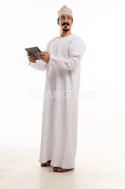 Omani Man in Traditional Dress Holding Digital Tablet