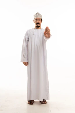 رجل عماني يقوم بإيماءة التوقف بخلفية بيضاء