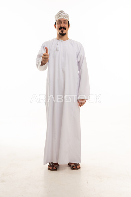 رجل عماني بالزي التقليدي يقدم إشارة الإبهام للأعلى