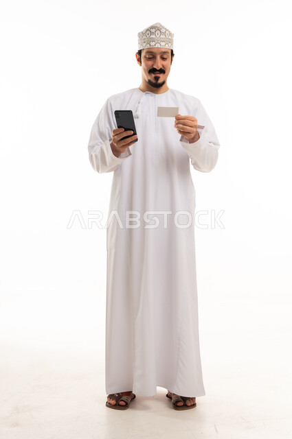 Omani Man Using Smartphone and Credit Card in Studio