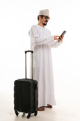 رجل عماني مع حقيبة سفر وهاتف ذكي خلفية بيضاء