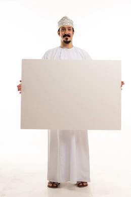 رجل عماني بالزي التقليدي يحمل لوحة بيضاء فارغة