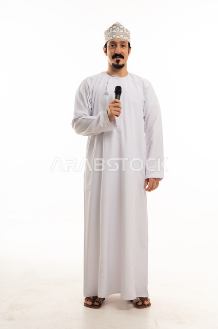 رجل عماني بالزي التقليدي يمسك ميكروفون