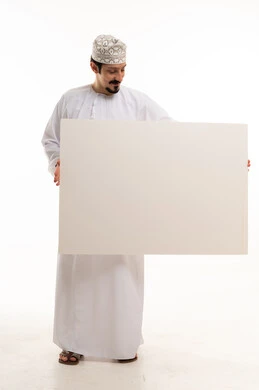 رجل عماني يحمل لوحة بيضاء فارغة في استوديو