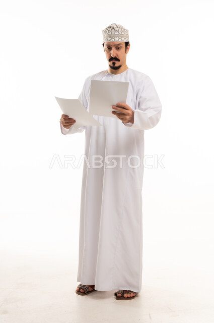 Omani Man Reading Documents in Traditional Attire