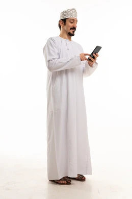 رجل عماني بالزي التقليدي يستخدم الهاتف الذكي