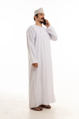 رجل عماني بالدشداشة يتحدث عبر الهاتف المحمول