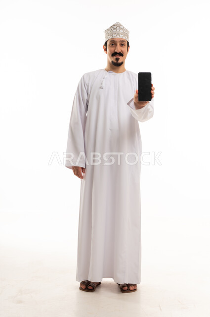 رجل عماني يحمل هاتف ذكي بخلفية بيضاء
