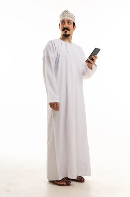 رجل عُماني بالزي التقليدي يمسك هاتف ذكي