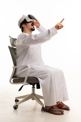 رجل عماني يرتدي نظارة واقع افتراضي على كرسي مكتب