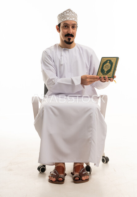 Omani Man Sitting with Holy Quran on White Background