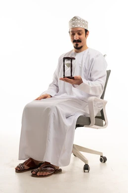 رجل عُماني يحمل ساعة رملية على خلفية بيضاء