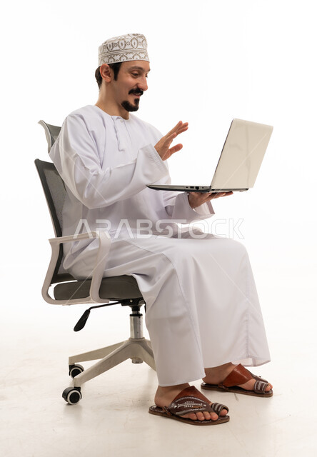 رجل عُماني يلوح لجهاز الكمبيوتر المحمول خلفية بيضاء