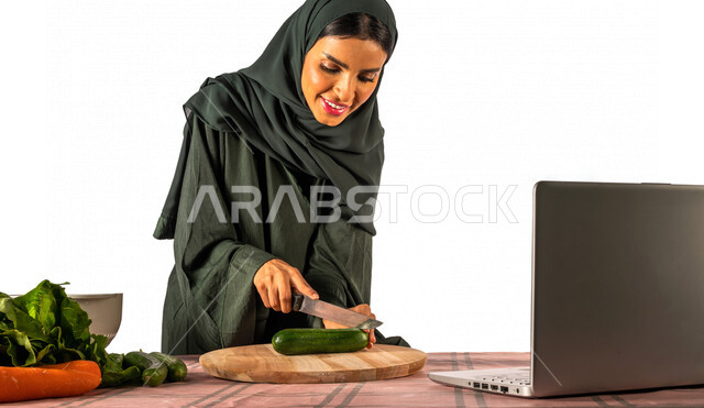 بورتريه لمرأة خليجية سعودية، تقف أمام طاولة عليها مجموعة من الخضراوات الطازجة، إجراء مكالمة فيديو عبر جهاز الحاسوب المحمول، مشاركة تحضير الوصفات على مواقع التواصل الاجتماعي، إعداد السلطات والأطباق الصحية، مفهوم النظام الغذائي الصحي، بث مباشر