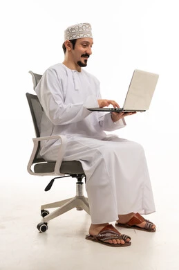 رجل عماني يستخدم جهاز كمبيوتر محمول