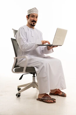 رجل عماني يستخدم لابتوب على كرسي مكتب