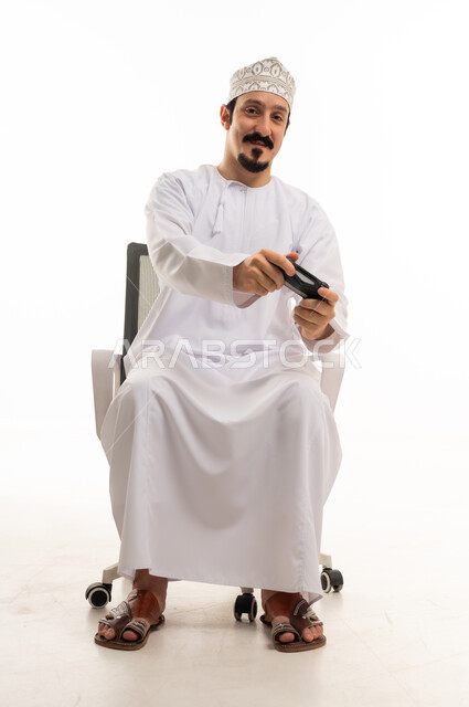 رجل عماني يلعب ألعاب الفيديو بخلفية بيضاء