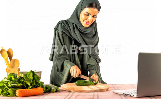 بورتريه لمرأة خليجية سعودية، تقف أمام طاولة عليها مجموعة من الخضراوات الطازجة، إجراء مكالمة فيديو عبر جهاز الحاسوب المحمول، مشاركة تحضير الوصفات على مواقع التواصل الاجتماعي، إعداد السلطات والأطباق الصحية، مفهوم النظام الغذائي الصحي، بث مباشر
