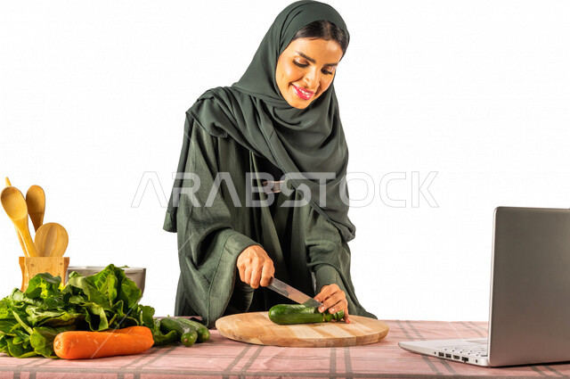 بورتريه لمرأة خليجية سعودية، تقف أمام طاولة عليها مجموعة من الخضراوات الطازجة، إجراء مكالمة فيديو عبر جهاز الحاسوب المحمول، مشاركة تحضير الوصفات على مواقع التواصل الاجتماعي، إعداد السلطات والأطباق الصحية، مفهوم النظام الغذائي الصحي، بث مباشر