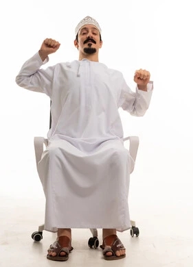 رجل عماني يتمطط على كرسي مكتب بخلفية بيضاء