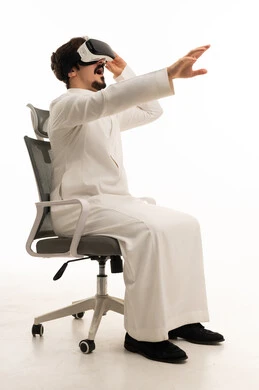 رجل سعودي يستخدم نظارة الواقع الافتراضي على كرسي
