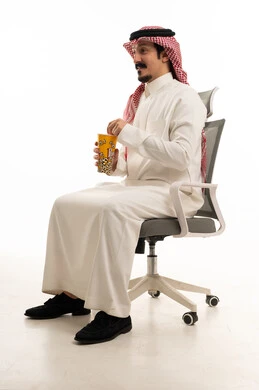 Saudi Man in Traditional Thobe Eating Popcorn