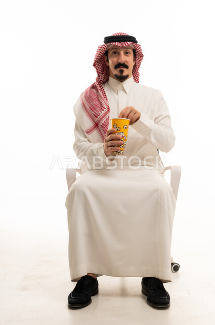 Saudi Man in Traditional Thobe Holding Popcorn