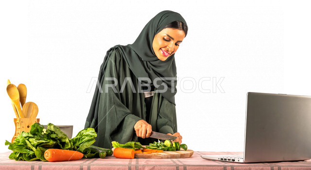 بورتريه لمرأة خليجية سعودية، تقف أمام طاولة عليها مجموعة من الخضراوات الطازجة، إجراء مكالمة فيديو عبر جهاز الحاسوب المحمول، مشاركة تحضير الوصفات على مواقع التواصل الاجتماعي، إعداد السلطات والأطباق الصحية، مفهوم النظام الغذائي الصحي، بث مباشر