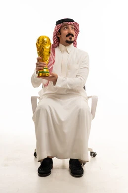 رجل سعودي يحمل كأس العالم في الاستوديو