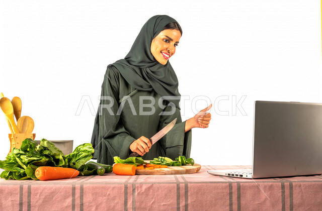 بورتريه لمرأة خليجية سعودية، تقف أمام طاولة عليها مجموعة من الخضراوات الطازجة، إجراء مكالمة فيديو عبر جهاز الحاسوب المحمول، مشاركة تحضير الوصفات على مواقع التواصل الاجتماعي، إعداد السلطات والأطباق الصحية، مفهوم النظام الغذائي الصحي، بث مباشر
