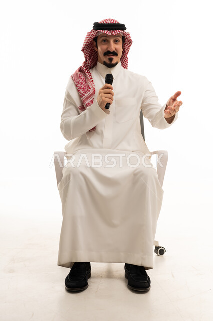 رجل سعودي مع ميكروفون على كرسي مكتب في استوديو