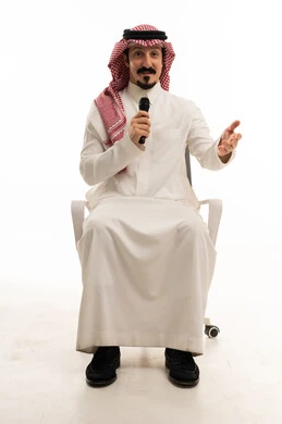 رجل سعودي مع ميكروفون على كرسي مكتب في استوديو