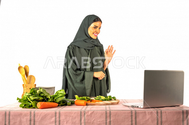 بورتريه لمرأة خليجية سعودية، تقف أمام طاولة عليها مجموعة من الخضراوات الطازجة، إجراء مكالمة فيديو عبر جهاز الحاسوب المحمول، مشاركة تحضير الوصفات على مواقع التواصل الاجتماعي، إعداد السلطات والأطباق الصحية، مفهوم النظام الغذائي الصحي، بث مباشر