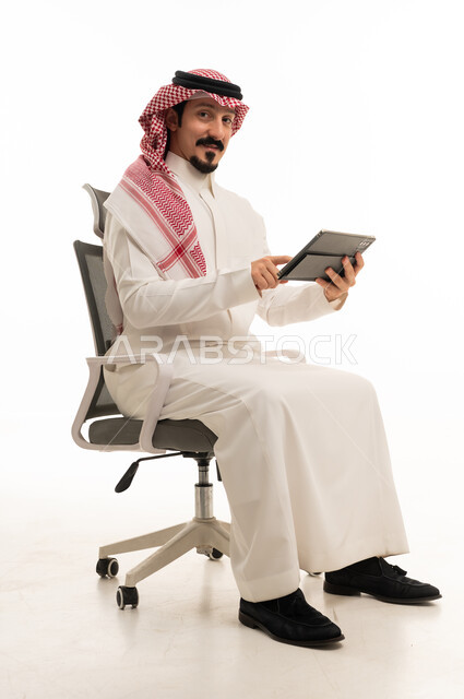Saudi Businessman Using Tablet on Office Chair