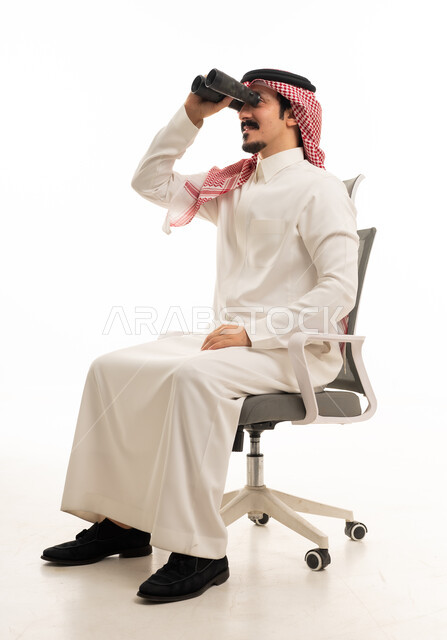 رجل سعودي يحمل منظاراً على كرسي مكتب