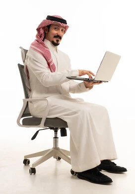 رجل سعودي يستخدم اللابتوب على كرسي مكتب