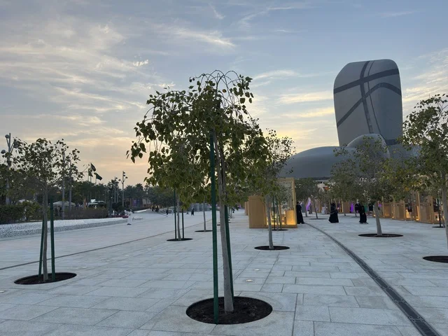 مركز إثراء الظهران مع الأشجار في ساحة خارجية وقت الغروب