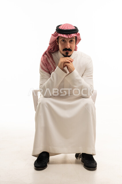 Saudi Man in Traditional Attire Sitting in Studio