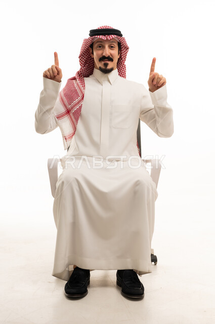 رجل سعودي بالزي التقليدي يشير للأعلى على خلفية بيضاء