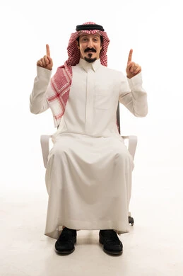 رجل سعودي بالزي التقليدي يشير للأعلى على خلفية بيضاء