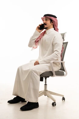 رجل أعمال سعودي جالس على كرسي يتحدث بالهاتف