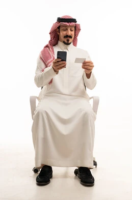 رجل سعودي يستخدم الهاتف والبطاقة الائتمانية